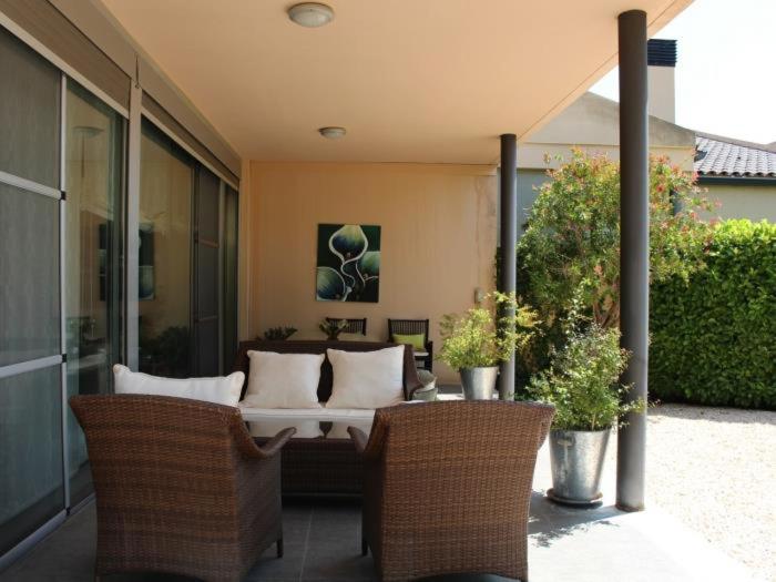 a patio with a couch and chairs and plants at Homing Golf Bonmont 12 in Bonmont Terres Noves