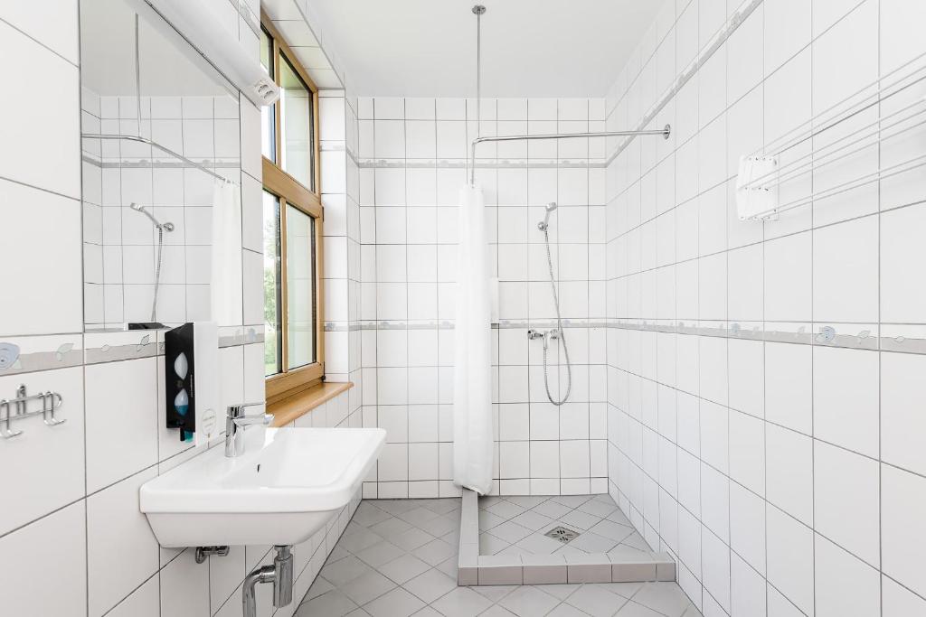bagno bianco con lavandino e doccia di Kurgo Villa hotel a Pärnu