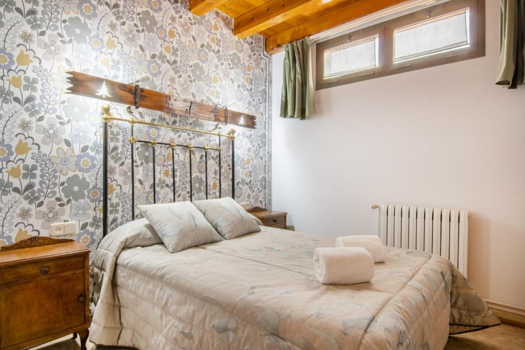 1 dormitorio con 1 cama en una habitación con papel pintado en Casa Batlle Boix en Les Iglésies