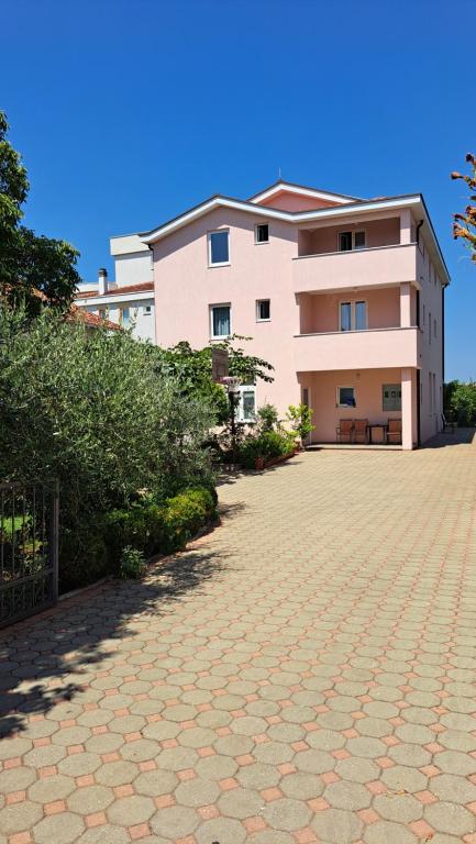 un bâtiment avec une allée en briques en face de celui-ci dans l'établissement Anđela, à Međugorje