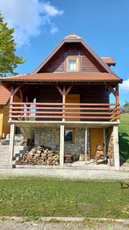 a house with a pile of fire wood in front of it at Brvnare Libero TARA in Sekulić 