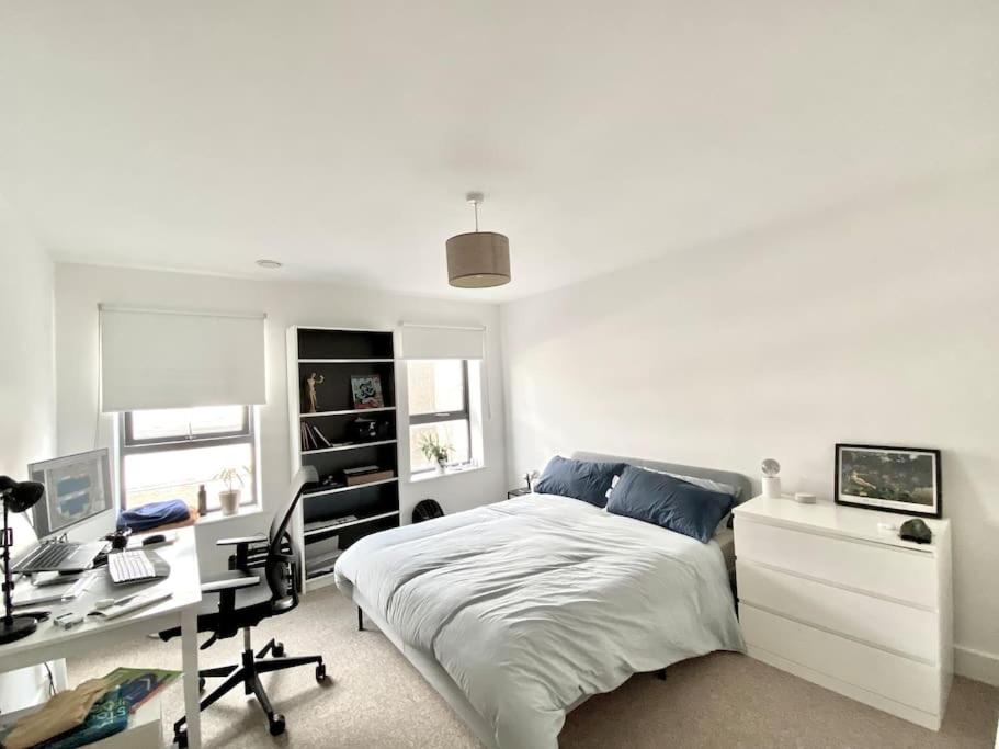 a bedroom with a bed and a desk and a computer at Large 2bed flat near TowerBridge in London