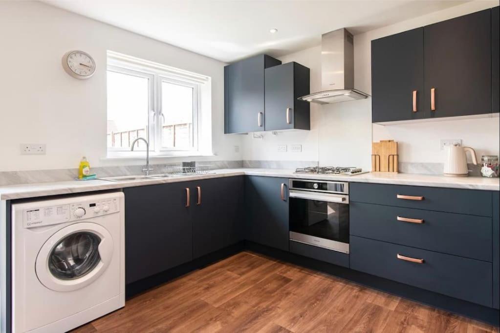a kitchen with blue cabinets and a washing machine at Charming 2 Bed Home in Edwalton in Nottingham