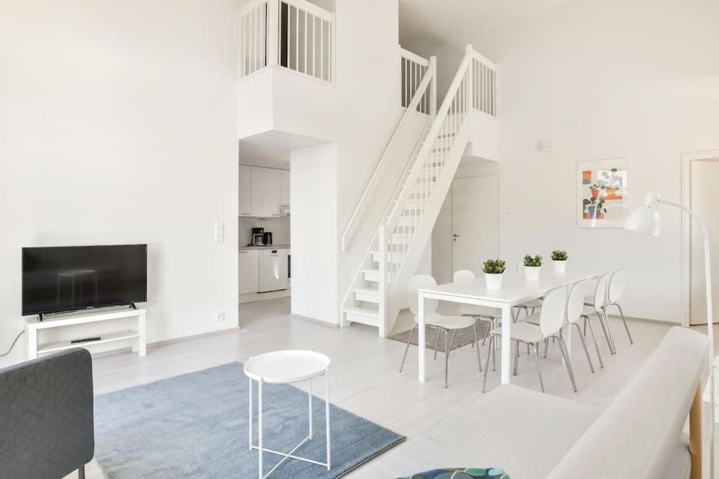 a white living room with a table and chairs at Kotimaailma - Kaunis saunallinen kattohuoneisto 10lle, Espoon keskustassa in Espoo