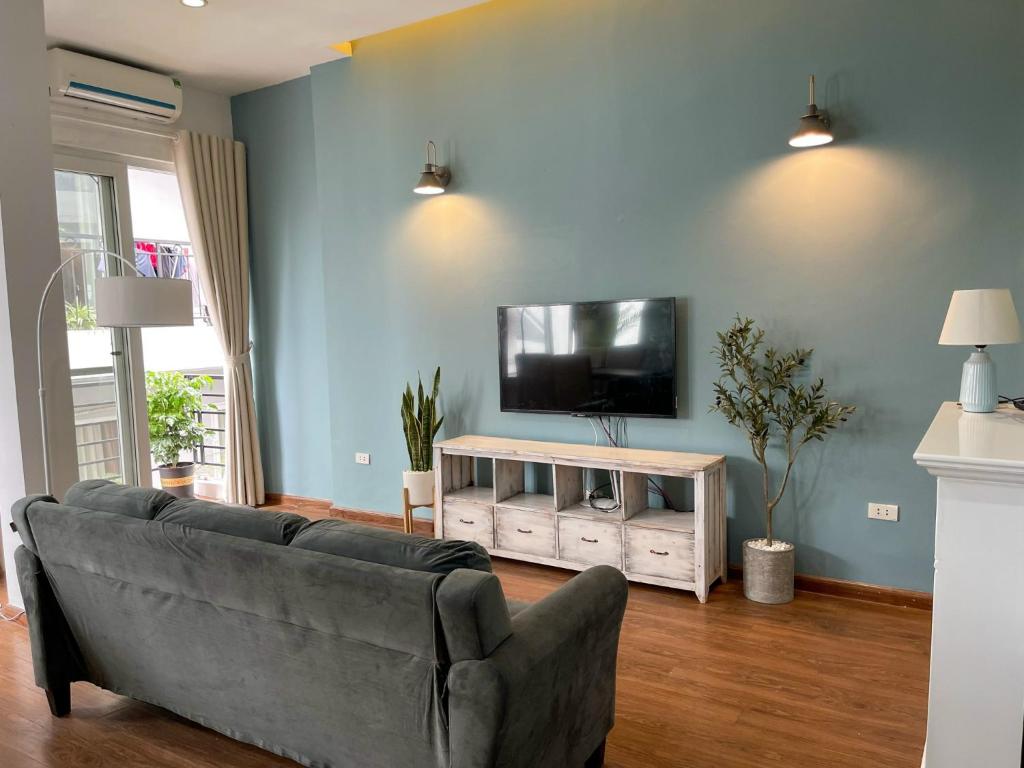 uma sala de estar com um sofá e uma televisão de ecrã plano em Annam The Residence - Westlake Central 2Bedrooms em Hanói