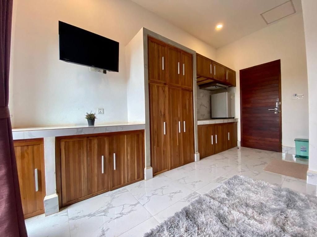 uma sala de estar com armários de madeira e uma televisão de ecrã plano em Siemreap City Residence em Siem Reap
