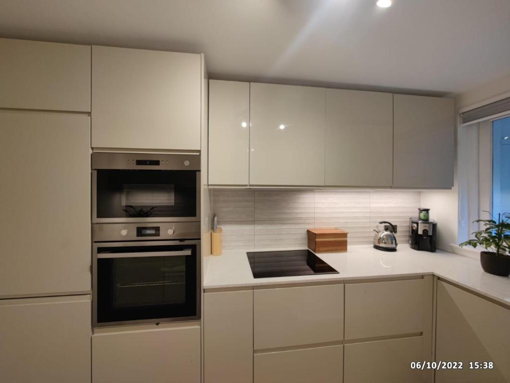 a kitchen with stainless steel appliances and white cabinets at The GG Spot in South Kensington Central London 2 Bedroom Apartment by Wild Boutique Apartments in London