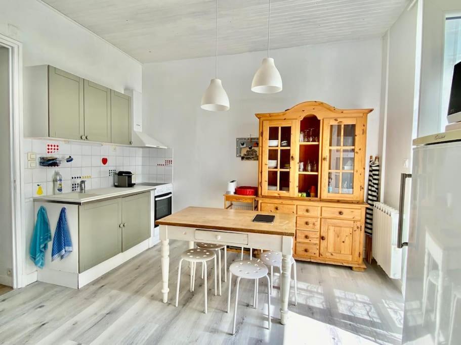a kitchen with a wooden table and some stools at Appartement vue mer Merlimont in Merlimont
