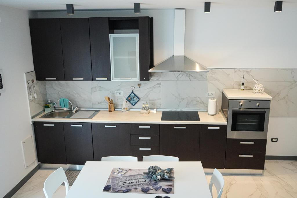 a kitchen with black cabinets and a table with chairs at La Casa di Sossy in Civitanova Marche