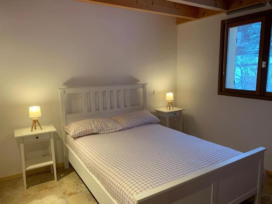 a bedroom with a white bed with two night stands at APPARTEMENT DANS CHALET 6 PERSONNES in Vallouise