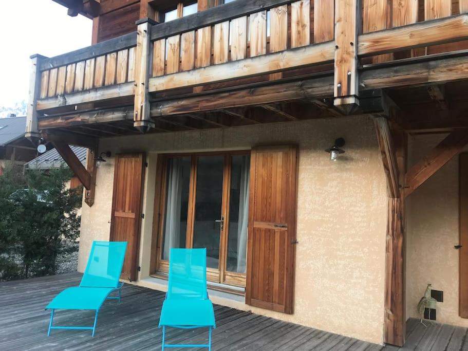 two blue chairs on a deck with a balcony at APPARTEMENT DANS CHALET 6 PERSONNES in Vallouise