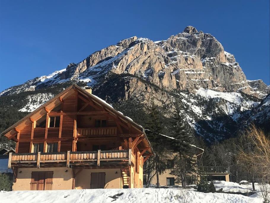 a log cabin in front of a mountain at APPARTEMENT DANS CHALET 6 PERSONNES in Vallouise