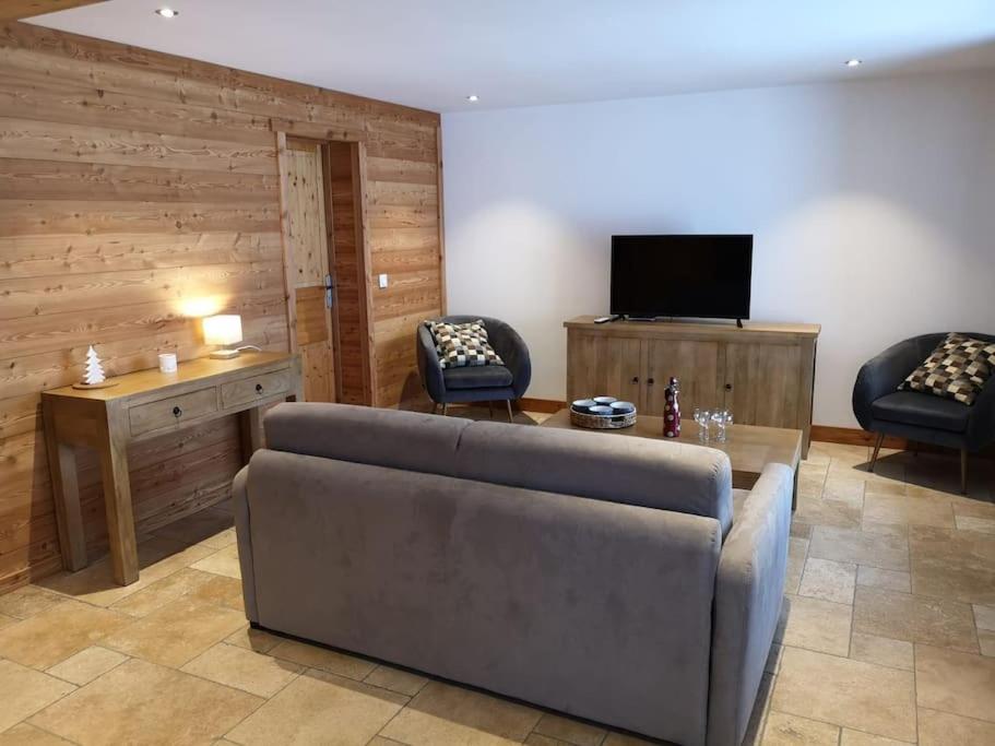 a living room with a couch and a tv at APPARTEMENT DANS CHALET 6 PERSONNES in Vallouise
