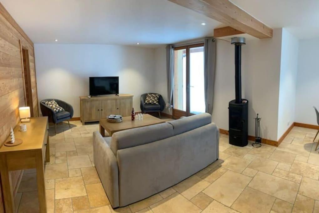 a living room with a couch and a tv at APPARTEMENT DANS CHALET 6 PERSONNES in Vallouise