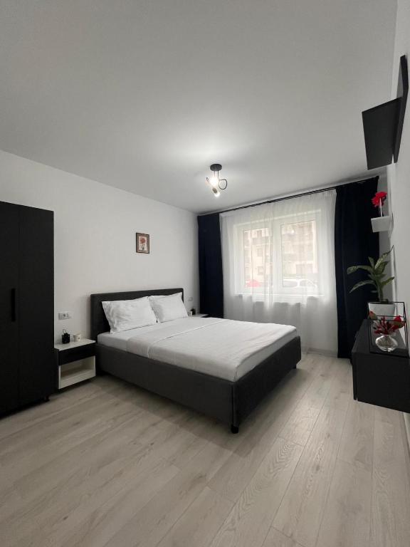 Un dormitorio con una cama grande y una ventana. en Apartament R - Brașov, en Brasov