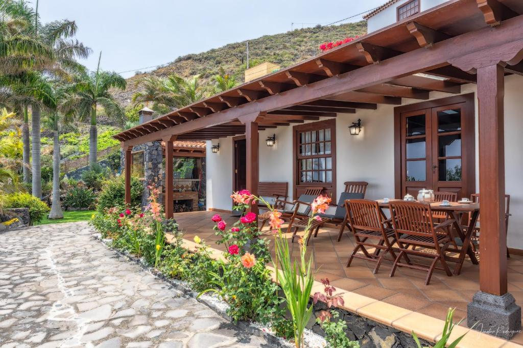 un patio avec une table, des chaises et des fleurs dans l'établissement Lightbooking Los Morales Villa de Mazo, à Mazo