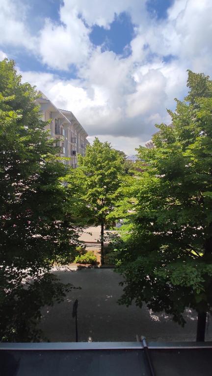 uma vista para um edifício e árvores a partir de uma janela em Appartamento Adria em Bibione