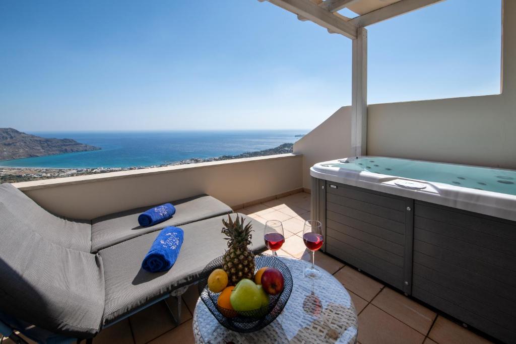 a room with a tub and a table with a bowl of fruit at Stefanos Village Hotel in Plakias