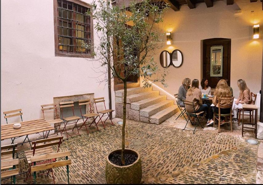 un grupo de personas sentadas en una mesa en un edificio en Hostel Quartier Leon Jabalquinto, en León