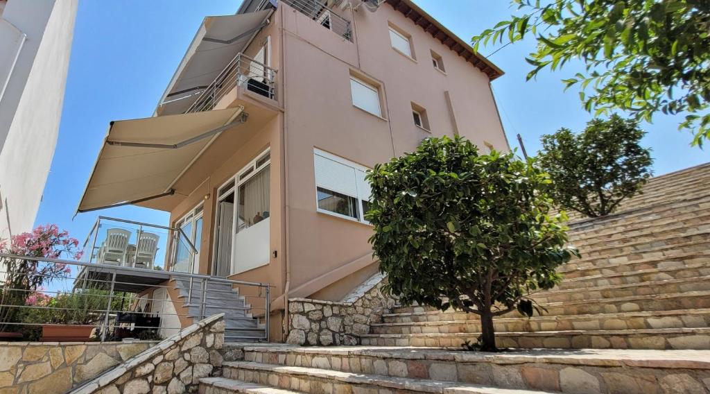 a pink house with stairs leading up to it at Family Apartment in Derveni