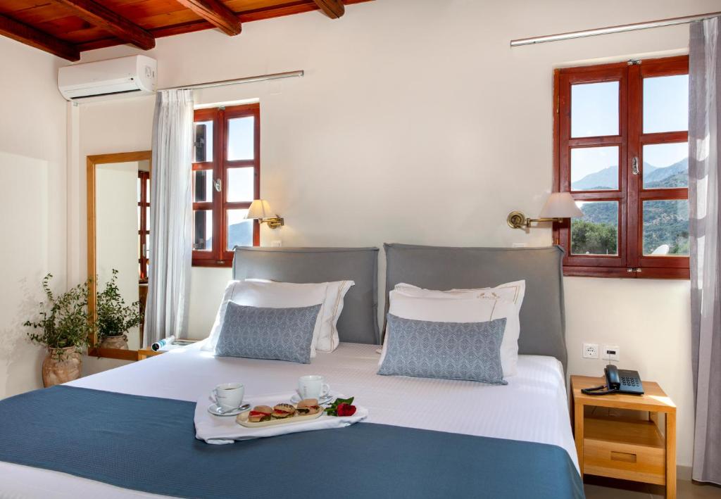 a bedroom with a bed with a tray of food on it at Stefanos Village Hotel in Plakias