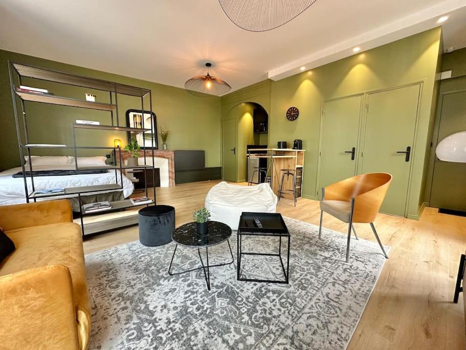 a living room with a bed and a table and chairs at Bel appart Bd Foch in Angers