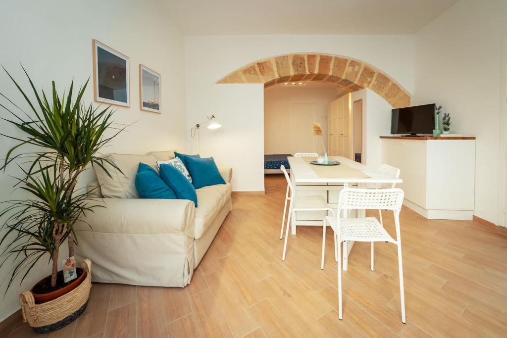 ein Wohnzimmer mit einem Sofa, einem Tisch und Stühlen in der Unterkunft Confortevole Open Space [Centro Storico] in Marsala