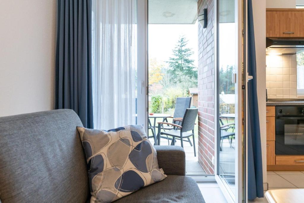 uma sala de estar com um sofá e uma varanda em Haus Roland Wohnung 03 em Zinnowitz
