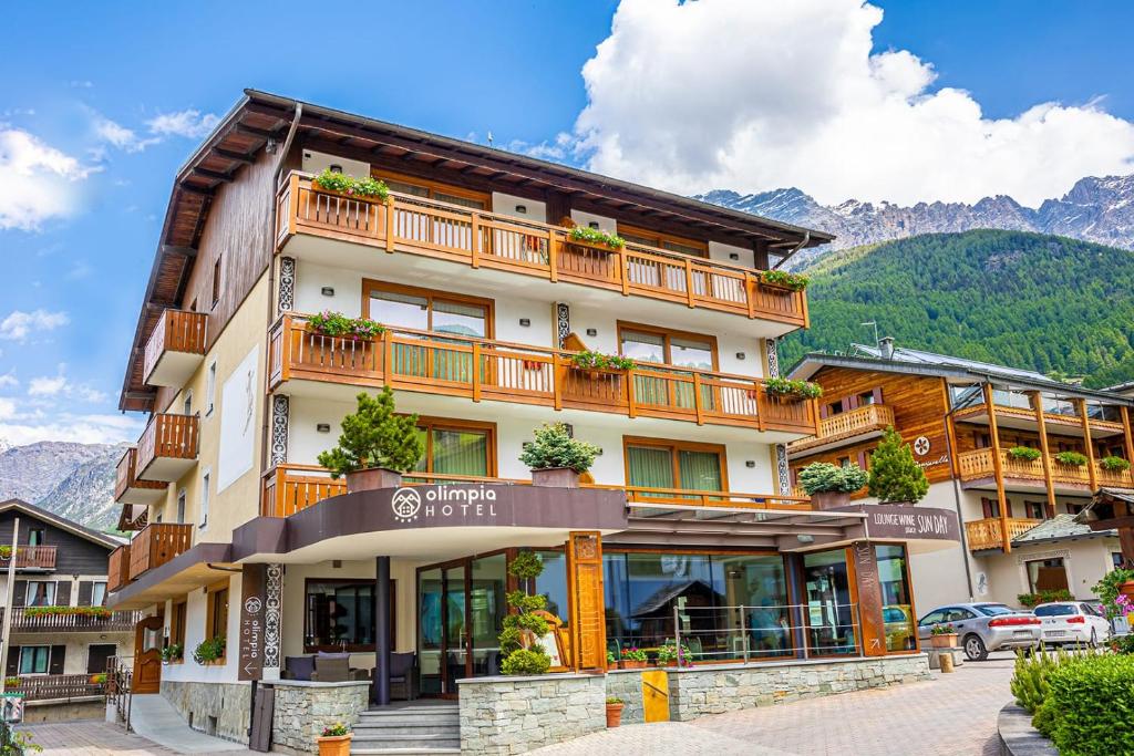 ein großes Gebäude mit Balkon auf der Seite in der Unterkunft Olimpia Hotel in Bormio