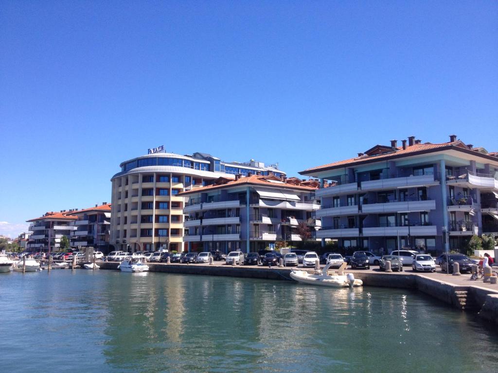 a group of buildings next to a river with boats at Costa Azzurra Apartment in Grado