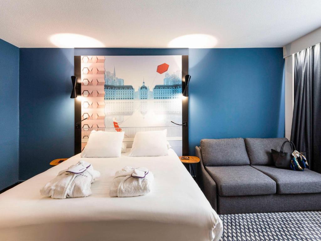 um quarto de hotel com uma cama e um sofá em Mercure Bordeaux Centre Ville em Bordeaux