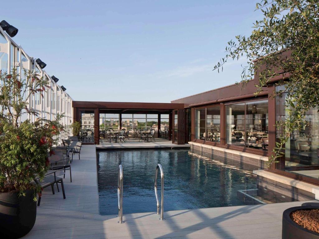 - une piscine au milieu d'un bâtiment dans l'établissement Pullman La Pléiade Montpellier Centre, à Montpellier