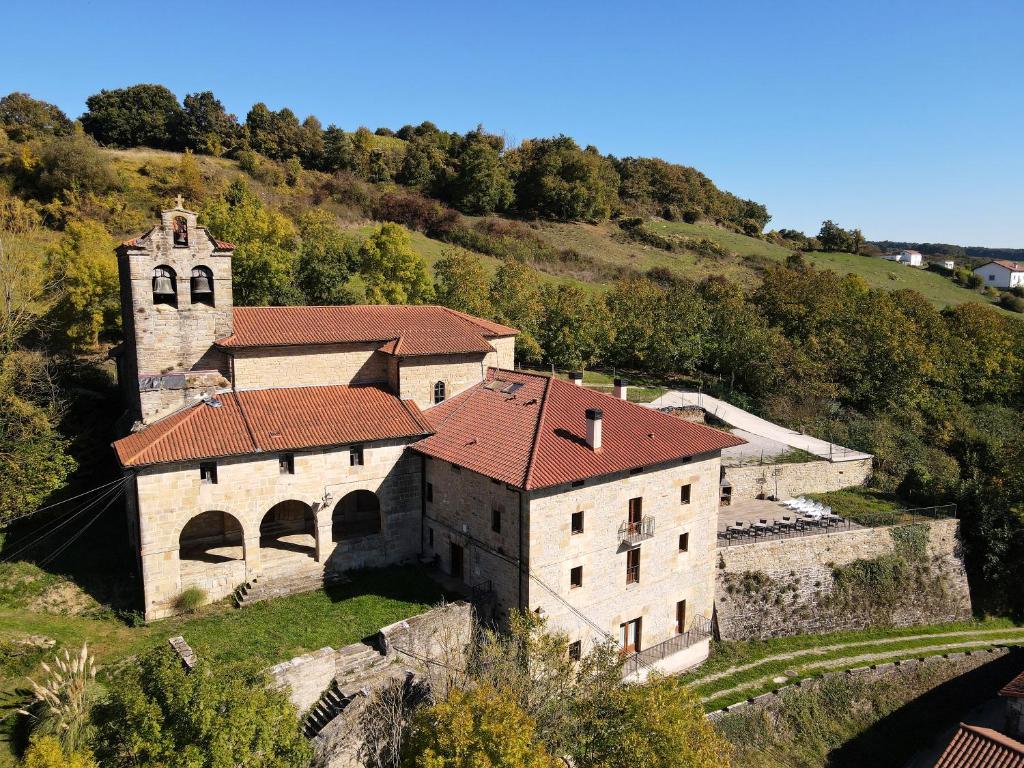 un antiguo edificio con una iglesia en una colina en Palacio de Aralar Alta Familias, en Oskotz