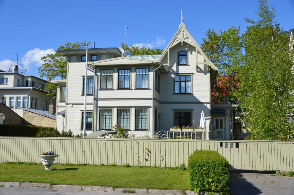 una casa blanca con una valla blanca en Papli Villa en Pärnu