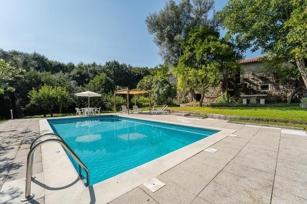 a swimming pool in a yard next to a house at Stone-crafted tranquility with a relaxing pool in Taide