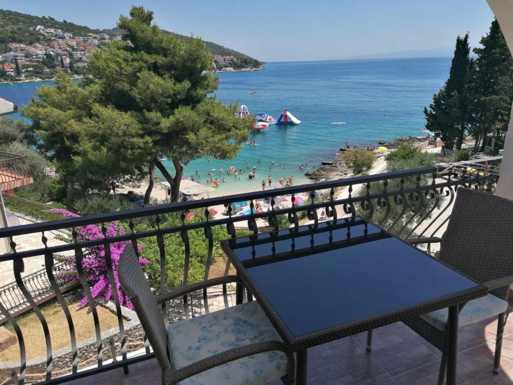 a balcony with a table and chairs and a beach at Villa Aequum in Trogir