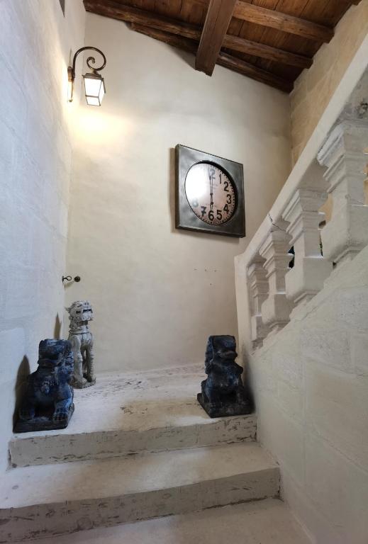 a stairway with a clock on the wall at Le Clos des Consuls in Tarascon