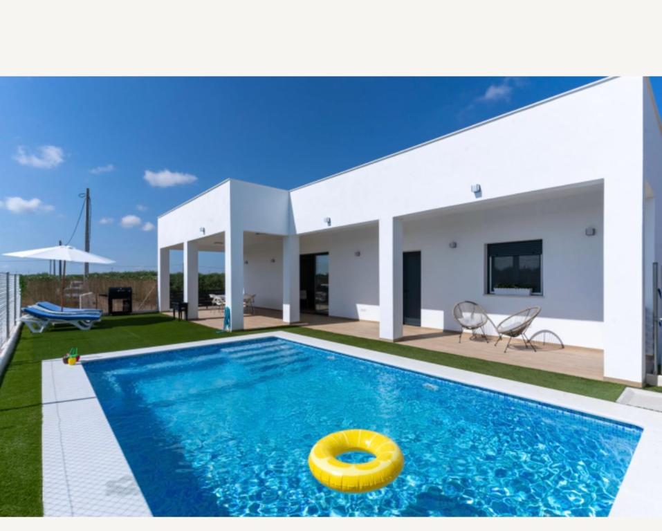 La casa grande village : حمام سباحة مع فريسبي أصفر أمام منزل