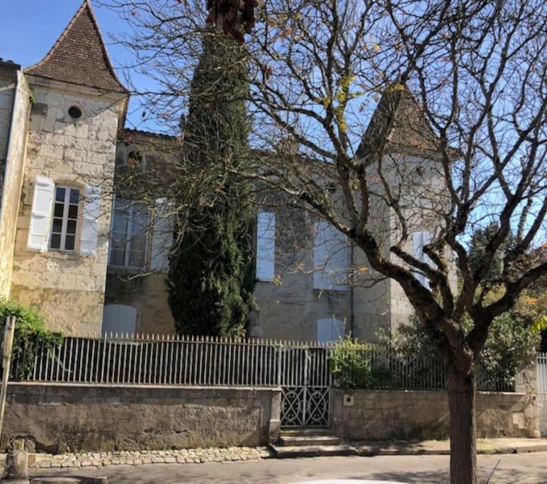 una casa con una valla y un árbol delante de ella en Appartement avec accès piscine et jardin dans hôtel particulier, en Nérac