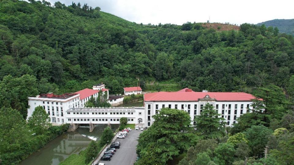 a group of buildings with cars parked in front of a mountain at Balneario de Cestona in Zestoa