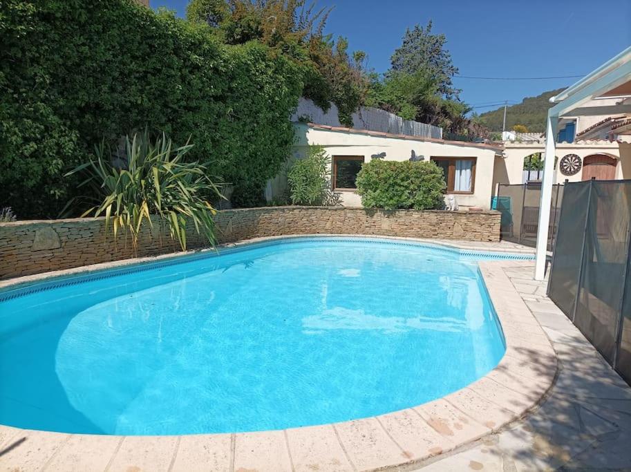 a large blue swimming pool in front of a house at Villa avec piscine privée proche Bandol/Beausset in Le Beausset