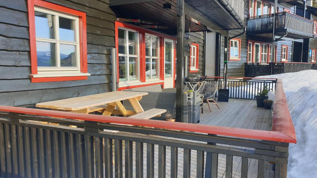 a wooden deck with a picnic table next to a building at Leilighet i Tråstølen Bavallen Voss in Skulestadmo