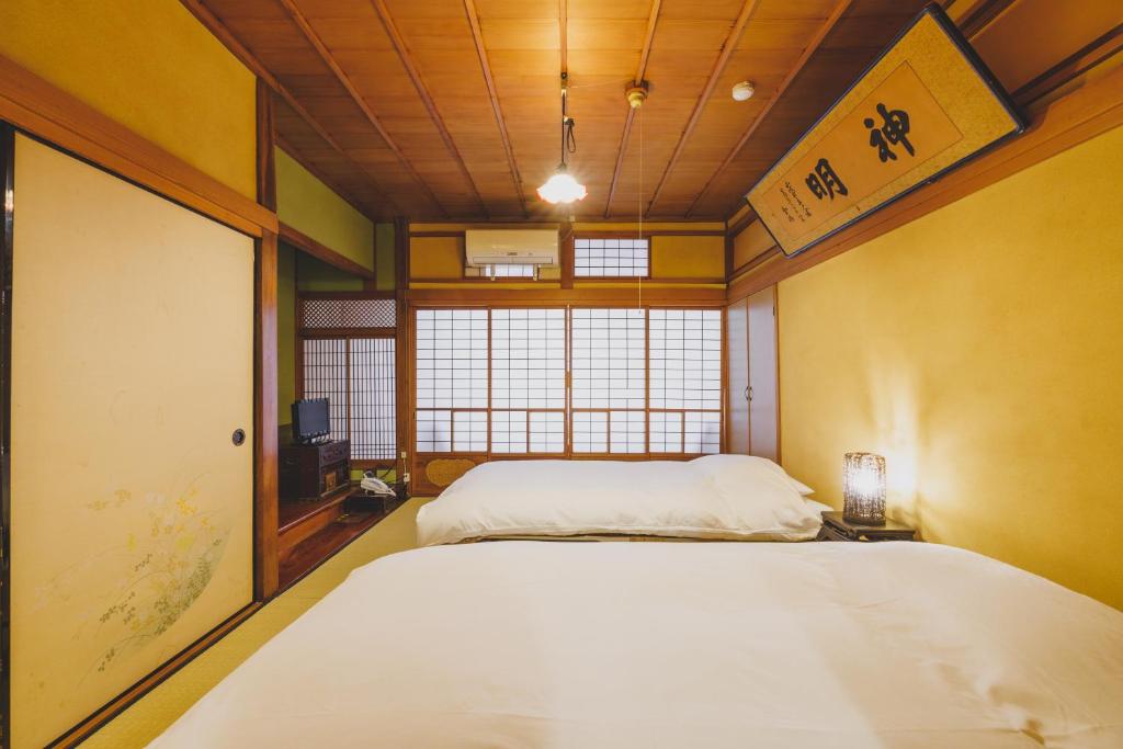 Postel nebo postele na pokoji v ubytování Ryokan Masuya