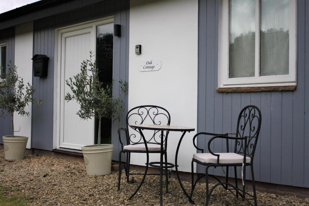 dos sillas y una mesa frente a una casa en Oak Cottage - Near Abergavenny, en Abergavenny