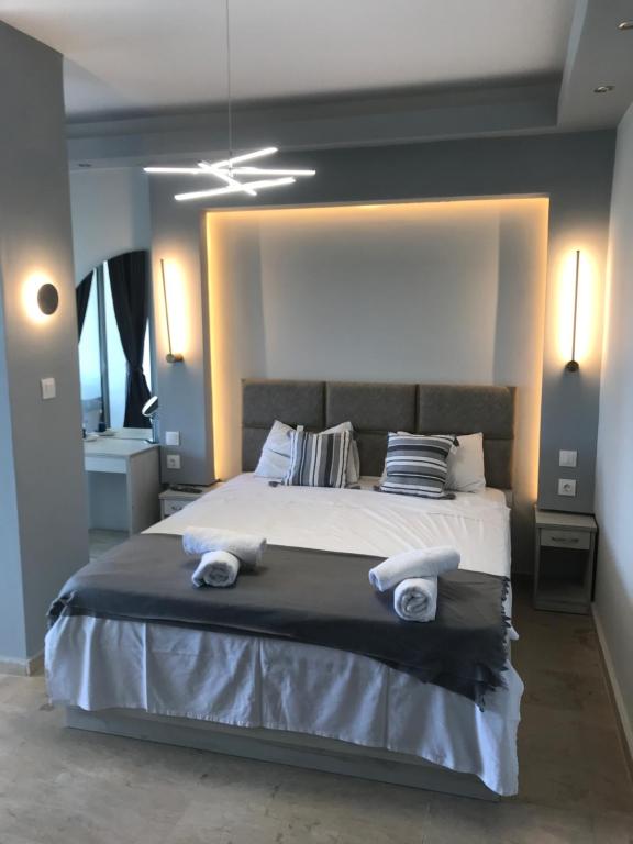 1 dormitorio con 1 cama grande y toallas. en Drenos Rooms view, en Kallithea Halkidikis