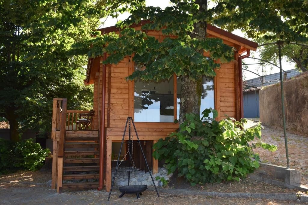 ein winziges Haus mit einer Veranda und einem Baum in der Unterkunft Refugio D Alecrim in Paredes