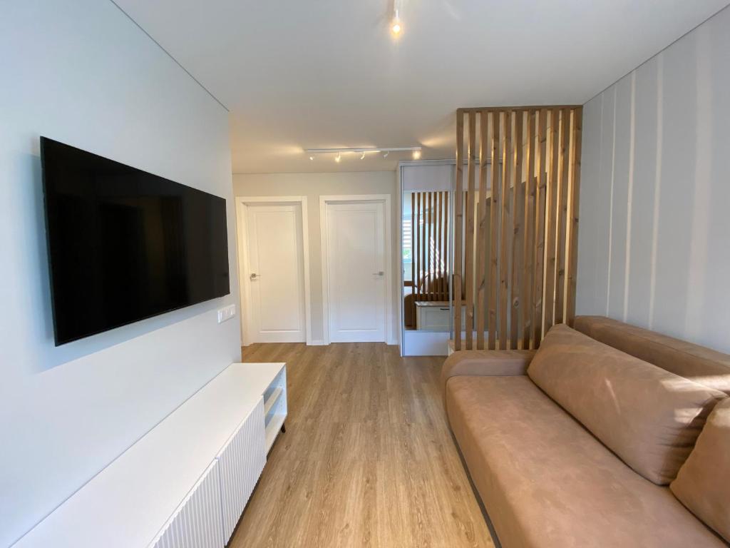 a living room with a couch and a flat screen tv at Pas Gerarduka in Nida