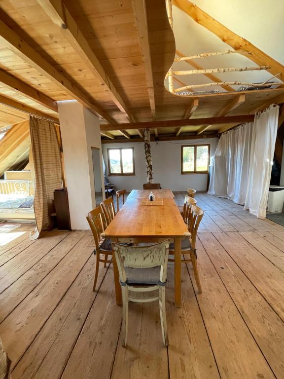 a dining room with a wooden table and chairs at Apartmán Půda Lhotka in Klášterec nad Orlicí