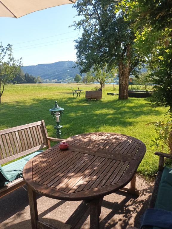 una mesa de madera y un banco en un campo en Hideaway en Zell am Moos