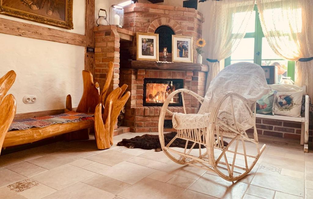 a living room with rocking chairs and a fireplace at Osada Między Drzewami in Braniewo